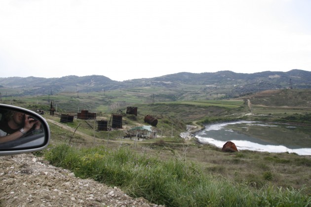 Abfälle der alten Förderindustrie liegen in der Landschaft herum.